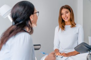 Gynäkologin im Gespräch mit einer lächelnden Patientin.