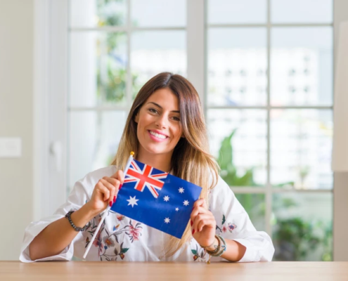 Frau zeigt australische Flagge in die Kamera.